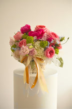 IN𝓃 Floral Studio Blush Basket arrangement with pink peonies, roses, lisianthus, hydrangeas, and green accents, tied with ribbons and pearls.