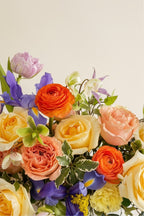 IN𝓃 Floral Studio pastel floral arrangement with roses, ranunculus, lisianthus, and irises in a white bowl.