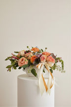 IN𝓃 Floral Studio Peach Garden arrangement: peach roses, ranunculus, and greenery in a white ceramic bowl with satin ribbons.