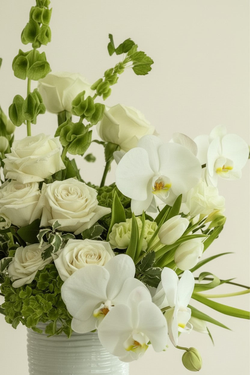 IN𝓃 Floral Studio Soft White Garden arrangement with ivory roses, white orchids, and green accents in a textured ceramic vase.