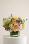 IN𝓃 Floral Studio Spring Garden Deluxe arrangement with roses, tulips, delphiniums, viburnum, stock, sweet peas, and hydrangeas in a glass vase.