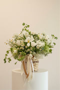 IN𝓃 Floral Studio White Meadow arrangement: tulips, chamomile, carnations, molucella, ranunculus butterfly, and greens in a woven basket with ribbons.