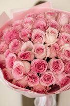 IN𝓃 Floral Studio blush pink rose bouquet wrapped in matching paper with elegant ribbon and pearl accents