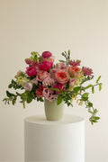 IN𝓃 Floral Studio Bloom Elegance arrangement: pink peonies, roses, lisianthus, stock, ranunculus, gerberas, jasmine in a ribbed vase.