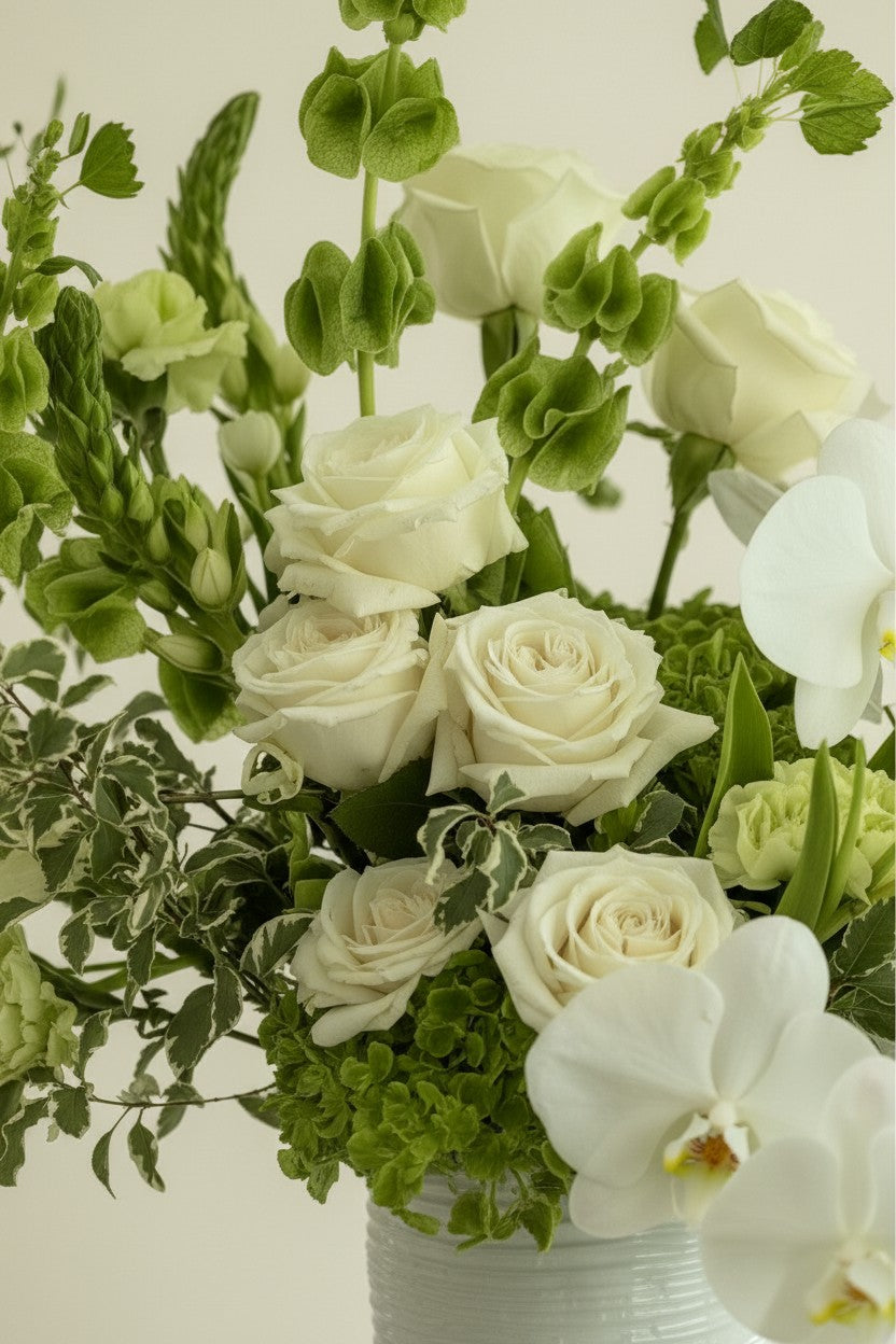 IN𝓃 Floral Studio Soft White Garden arrangement with ivory roses, white orchids, and green accents in a textured ceramic vase.