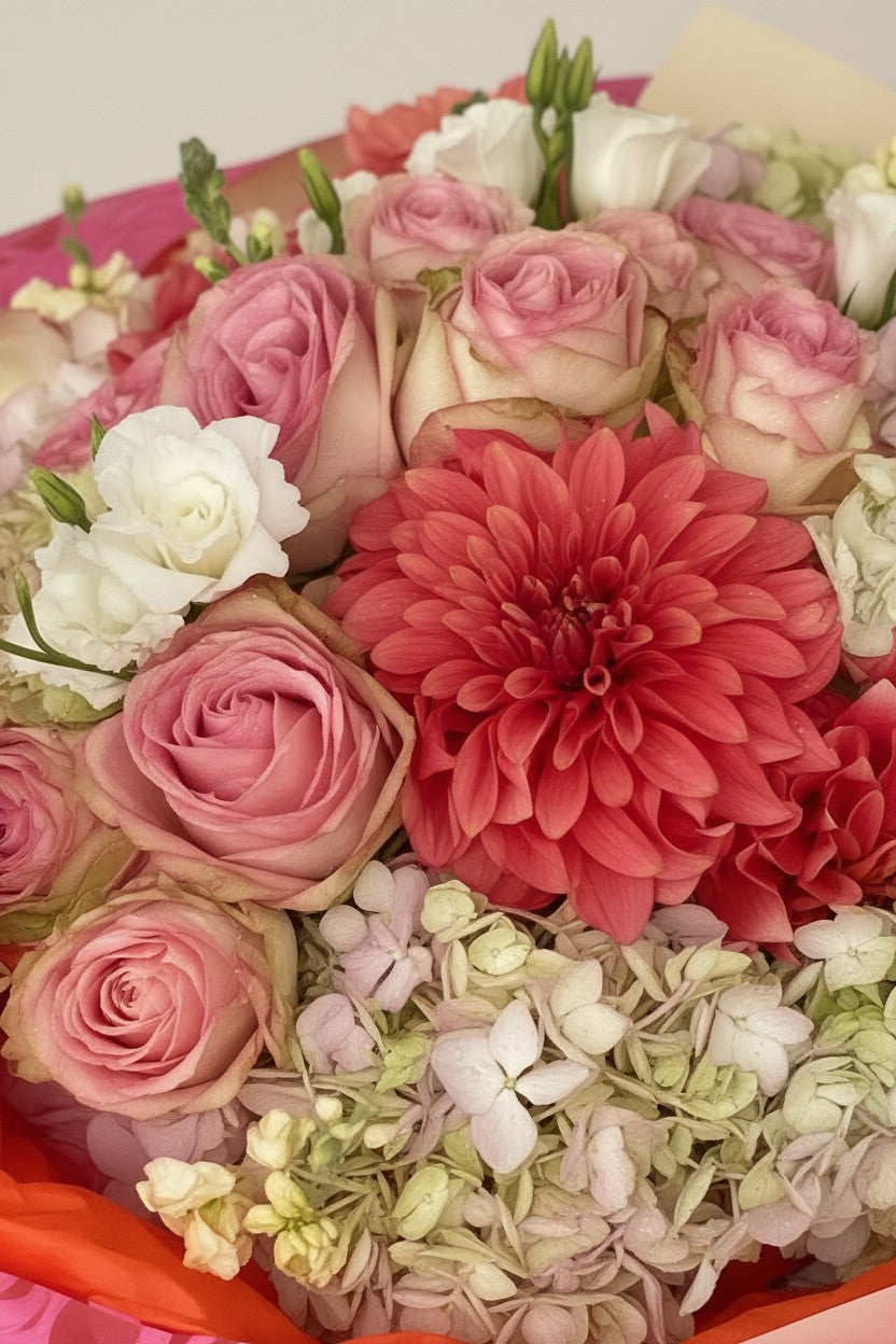 IN𝓃 Floral Studio garden bouquet with coral dahlias, blush pink roses, and cream hydrangeas in a lush arrangement.