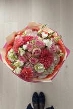 IN𝓃 Floral Studio signature hand-tied garden bouquet featuring coral dahlias, pink roses, and cream hydrangeas.