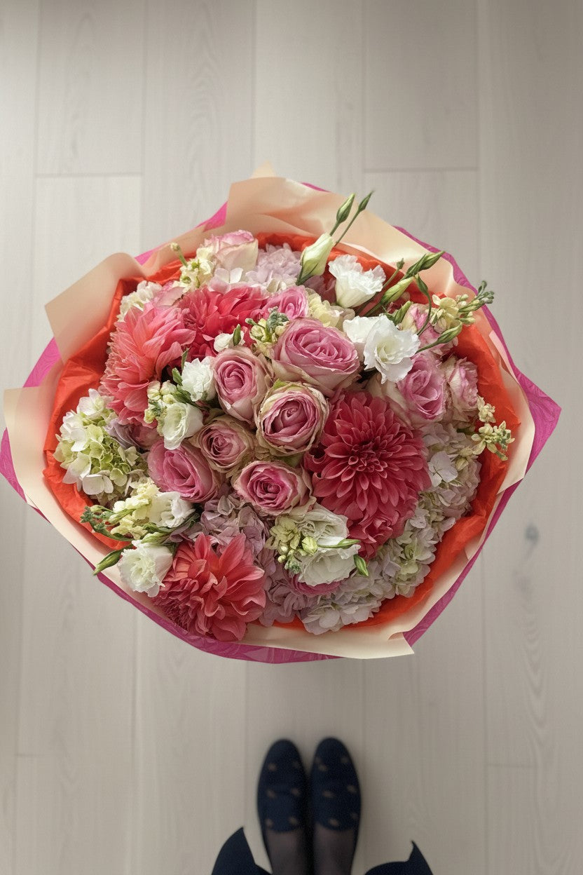 IN𝓃 Floral Studio signature hand-tied garden bouquet featuring coral dahlias, pink roses, and cream hydrangeas.