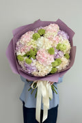 IN𝓃 Floral Studio mixed hydrangea bouquet in pastel pink, lavender, ivory, and blush with green viburnum accents. Size M.