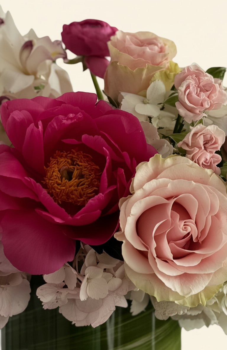 IN𝓃 Floral Studio Orchid Garden arrangement with pink peonies, roses, ranunculus, lisianthus, and white hydrangeas in a glass vase.