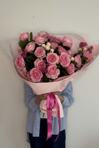 IN𝓃 Floral Studio Pink Garden Whisper bouquet, size L. Hand-tied pink garden and spray roses with white blooms and greenery.