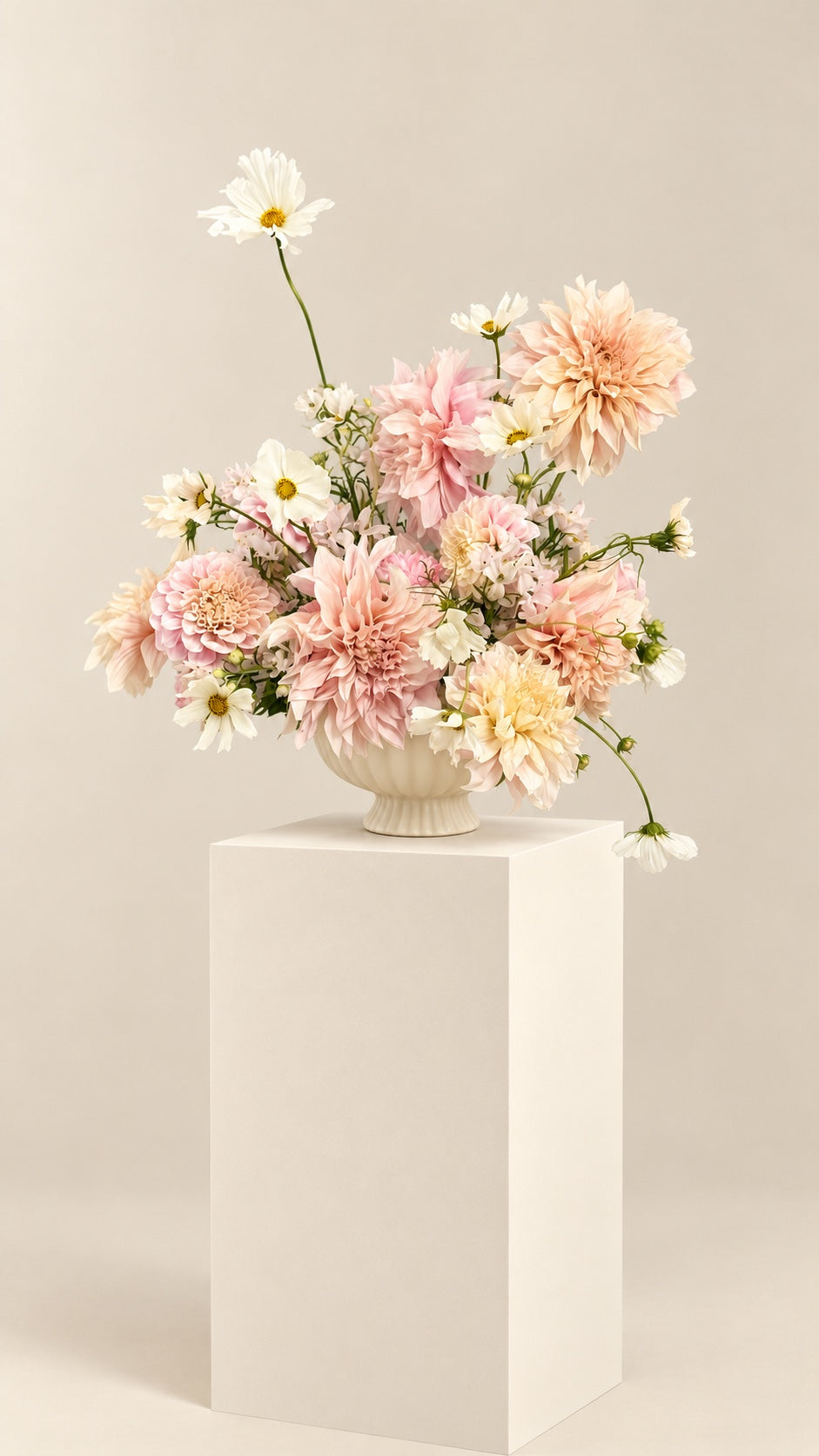Airy blush and cream arrangement in a ceramic bowl on an ivory pedestal