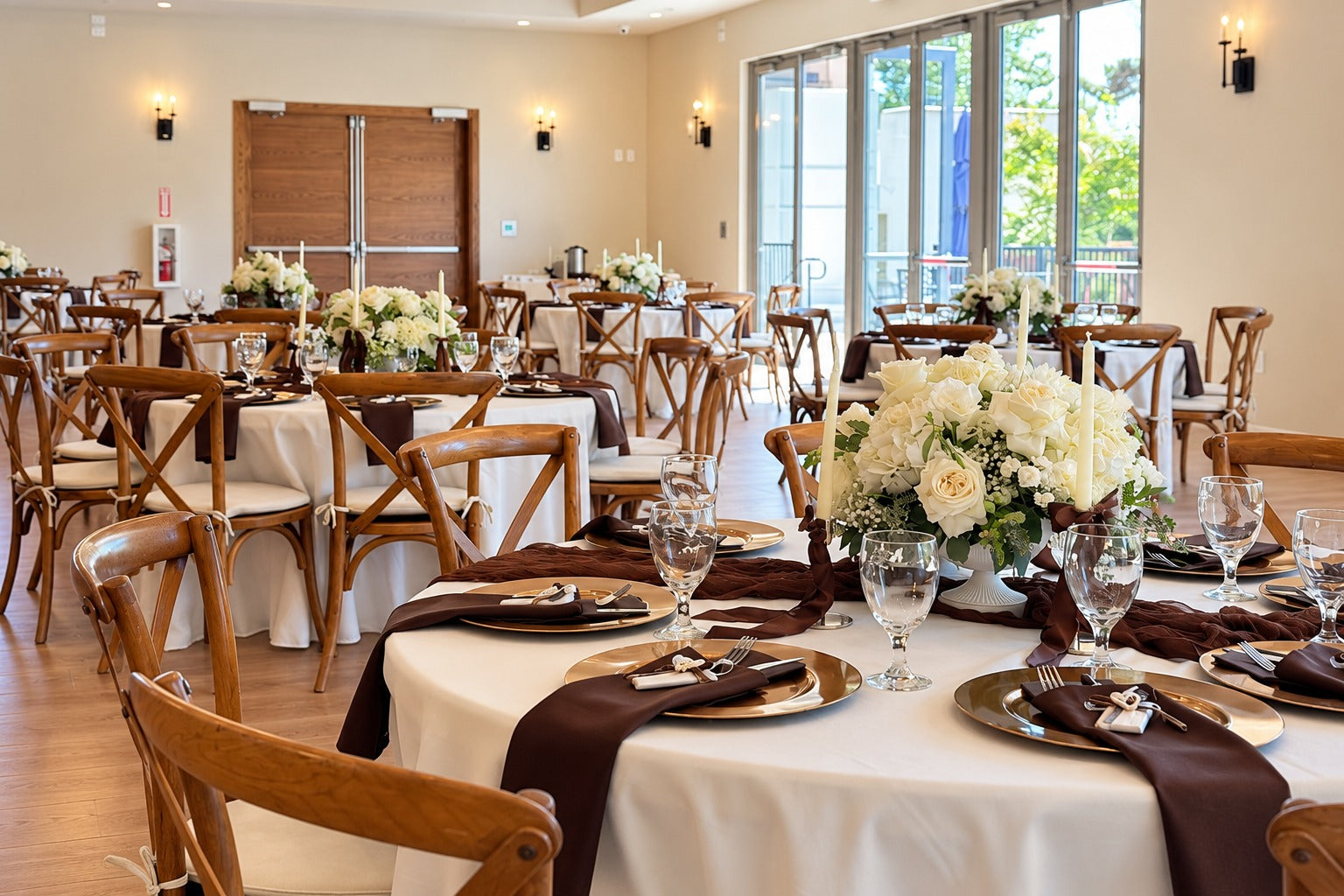 Ivory floral centerpieces throughout a warm reception setting