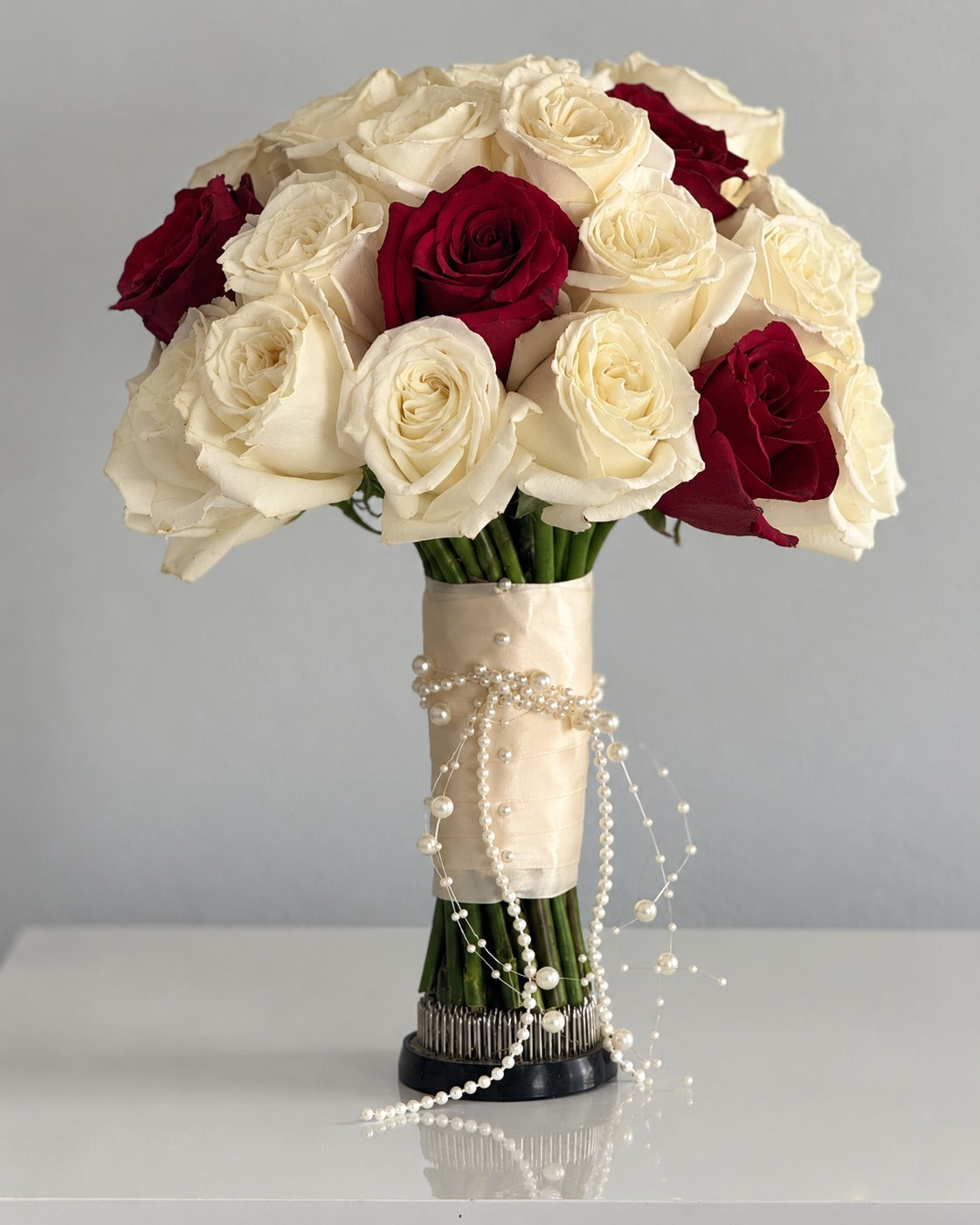 Ivory and burgundy rose bridal bouquet with satin and pearls